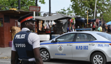 A police officer stands guard in the Half Way Tree neighborhood in Kingston, Jamaica. Photograph: Angela Weiss/AFP/Getty Images