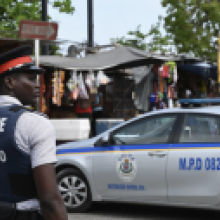 A police officer stands guard in the Half Way Tree neighborhood in Kingston, Jamaica. Photograph: Angela Weiss/AFP/Getty Images